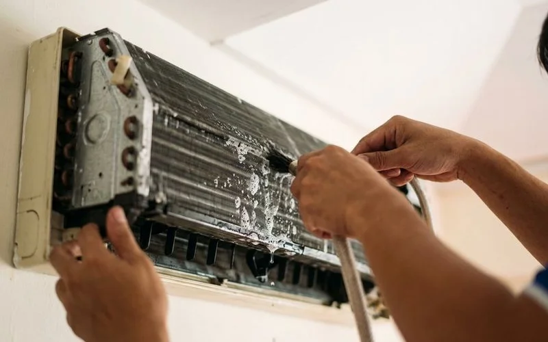 Close-up of aircon evaporator coil being cleaned with alkaline chemical solution during non-dismantle wash